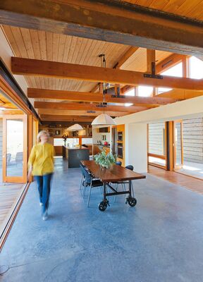 The dining table was custom made from a piece of partially petrified wood from EcoPDX in Portland. Mary Ellen designed the home's canvas lampshades, and for the dining room light, Wilf designed a pulley system to adjust its height.